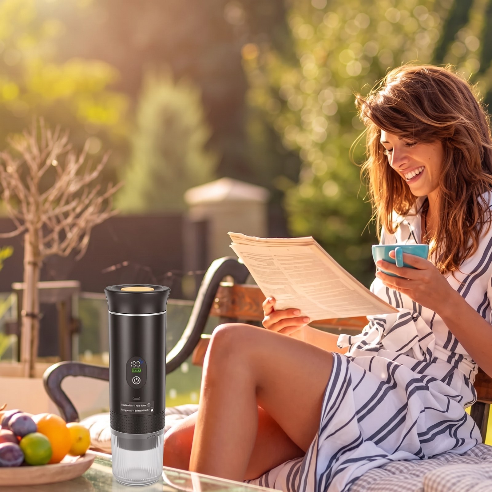 Woman reading and holding a coffee cup in a sunny garden with a portable espresso maker on the table
