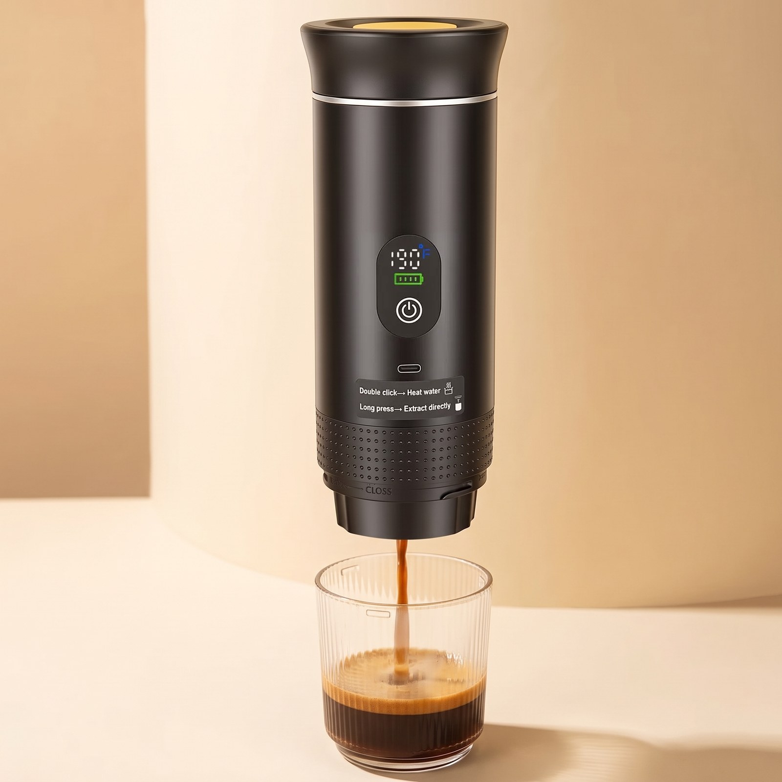 Portable espresso maker brewing into a clear glass against a cream studio backdrop